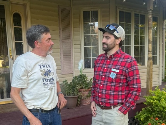 Ben Wieman talking with a local resident on the porch during door-to-door canvassing